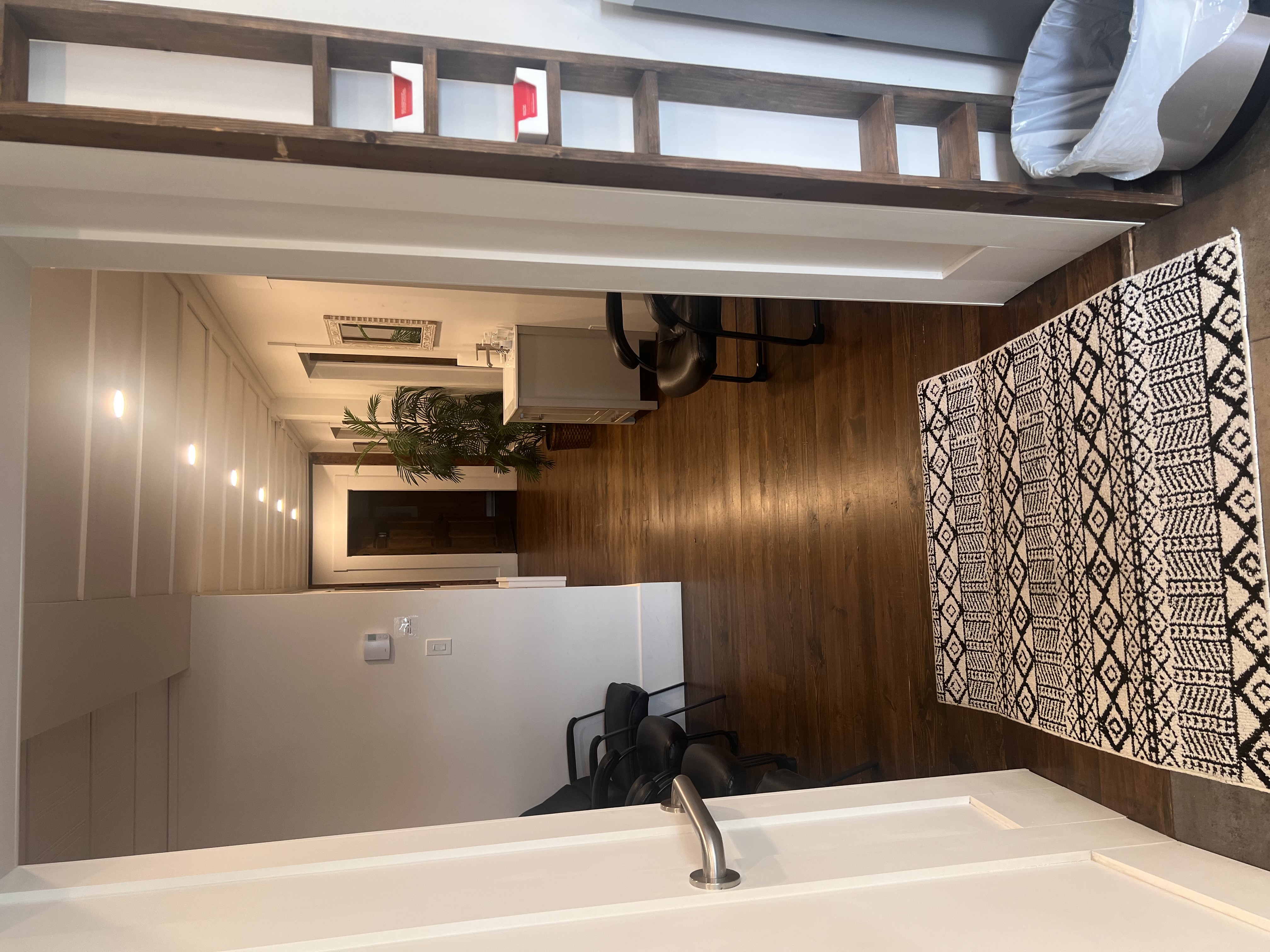 Espace d’attente de la clinique avec fauteuils, plante et plancher de bois