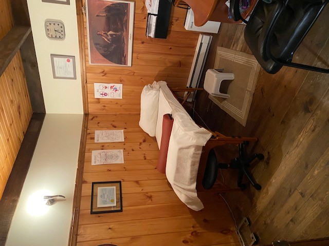 Salle de consultation avec table, tabouret et affiches anatomiques